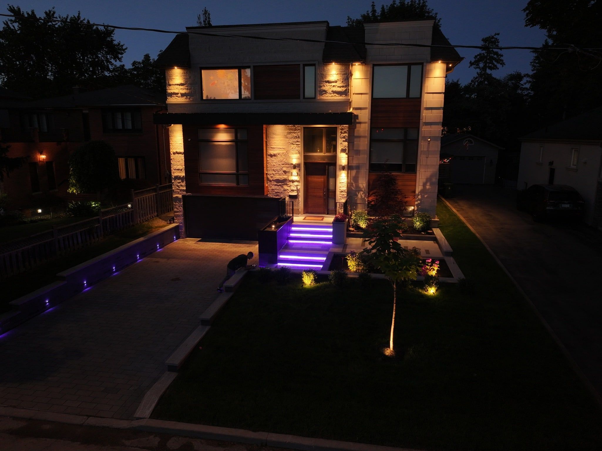 The same entry with the step lights in purple and the driveway edge lights in blue.