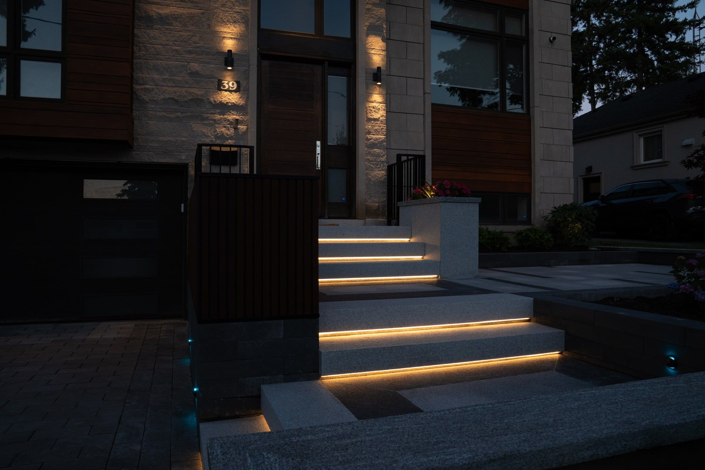 Warm light lines under the granite steps at night.